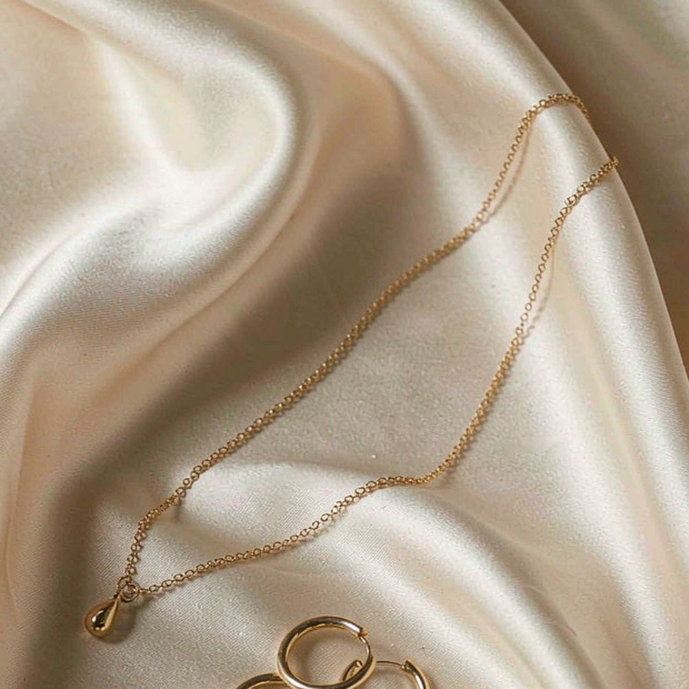 Offat fine gold chain bracelet styled on cream silk