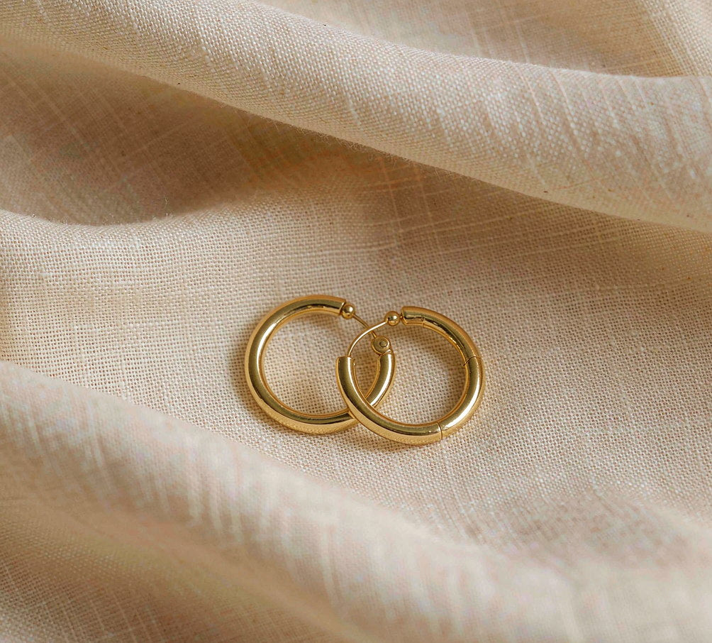 Offat small gold hoop earrings on cream linen