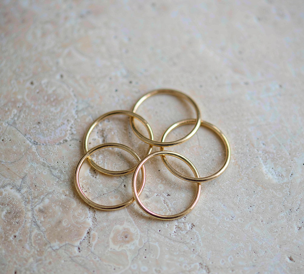 Offat gold stacking rings on pale limestone